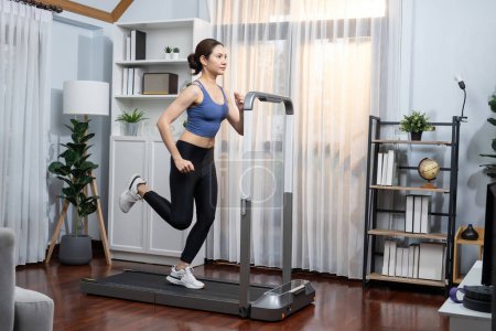 Téléchargez les photos : Energique et forte femme asiatique athlétique course machine à la maison. Poursuite de la forme physique et l'engagement à un mode de vie sain avec l'entraînement à domicile et la formation. Vigoureux - en image libre de droit