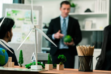 Photo for Mockup electric car with eco-friendly energy infrastructure on table with blurred background of productive business team meeting to contribute natural preservation and sustainable future. Quaint - Royalty Free Image