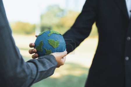 Photo for Earth day concept, businessman giving Earth globe to colleague as CSR corporate social responsible principle to promote environmental awareness and embrace ESG for greener and sustainable future. Gyre - Royalty Free Image
