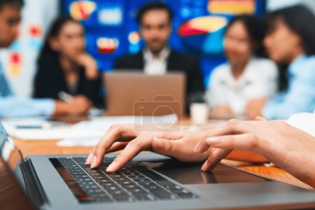 Photo for Closeup hand typing keyboard laptop with blurred background of business people using laptop to analyze financial data or data analysis display on screen background. Meticulous - Royalty Free Image