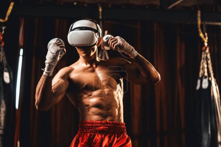 Téléchargez les photos : Entraînement de boxeur utilisant la technologie VR ou la réalité virtuelle, portant un casque VR avec une technique d'entraînement de boxe immersive utilisant un contrôleur pour améliorer ses compétences dans l'environnement du simulateur de boxe. Impulsion - en image libre de droit