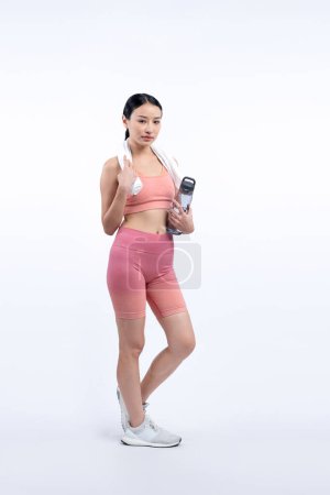 Foto de Mujer asiática atlética y deportiva descansando y bebiendo agua después de un entrenamiento intensivo de cardio. Ejercicio saludable y la búsqueda de estilo de vida de cuidado corporal en estudio tiro fondo aislado. Vigoroso - Imagen libre de derechos