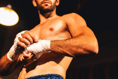 Photo for Caucasian boxer portrait with muscular and athletic body wrapping his hand or fist on the ring be fore the boxing fight match or training. Impetus - Royalty Free Image