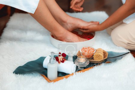 Téléchargez les photos : L'homme se livre à un massage des pieds dans un luxueux salon de spa tandis que le masseur donne une thérapie de réflexologie dans une station balnéaire d'ambiance légère ou un spa des pieds de l'hôtel. Tranquillité - en image libre de droit