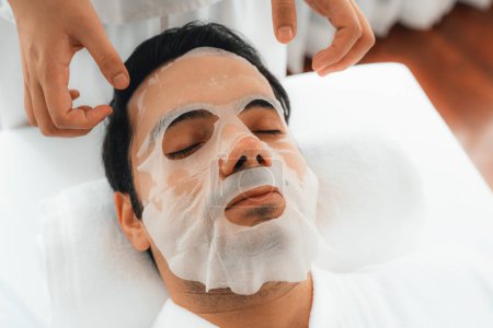 Photo for Serene modern daylight ambiance of spa salon, woman customer indulges in rejuvenating with facial skincare mask. Facial skin treatment and beauty cosmetology procedure for face. Quiescent - Royalty Free Image