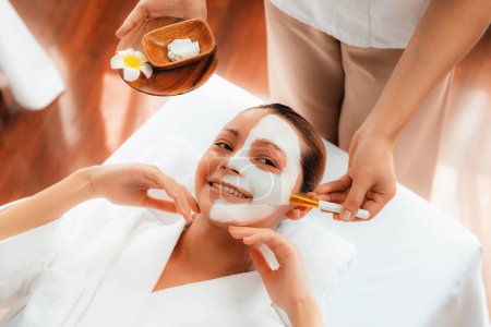 Photo for Serene ambiance of spa salon, woman customer indulges in rejuvenating with luxurious face cream massage with modern daylight. Facial skin treatment and beauty care concept. Quiescent - Royalty Free Image