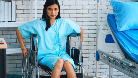 Foto de Joven mujer asiática feliz en silla de ruedas en un hospital. Concepto de atención médica y tratamiento del paciente. Jivy. - Imagen libre de derechos