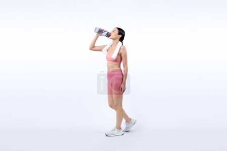 Photo for Athletic and sporty asian woman resting and drink water after intensive cardio workout training. Healthy exercising and fit body care lifestyle pursuit in studio shot isolated background. Vigorous - Royalty Free Image