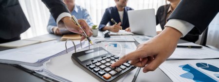 Photo for Auditor and accountant team working in office, analyze financial data and accounting record with calculator. Accounting company provide finance and taxation planning for profitable cash flow. Insight - Royalty Free Image