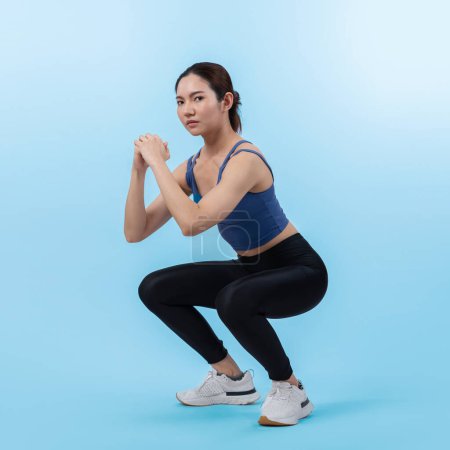 Photo for Vigorous energetic woman doing exercise. Young athletic asian woman strength and endurance training session as squat workout routine session. Full body studio shot on isolated background. - Royalty Free Image