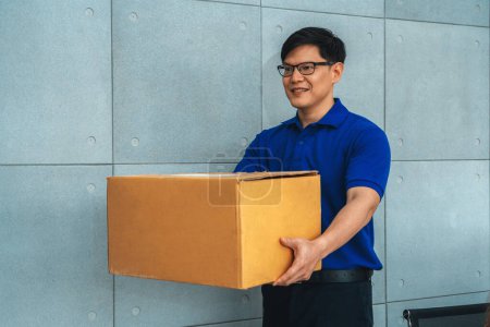 Téléchargez les photos : La personne de livraison transportant la boîte de colis à envoyer au client. Concept d'entreprise de livraison. Jivy - en image libre de droit