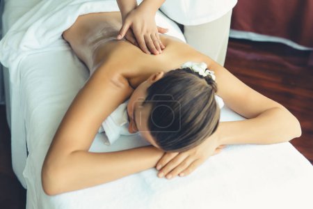 Téléchargez les photos : Femme caucasienne client appréciant relaxant massage spa anti-stress et dorloter avec la beauté loisirs de la peau dans la lumière du jour salon spa ambiant au complexe de luxe ou hôtel. Tranquillité - en image libre de droit