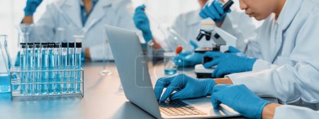 Photo for Dedicated group of scientist conduct chemical experiments and research in medical lab as groundbreaking developing for new vaccine drug or antibiotic and studying test result on laptop. Neoteric - Royalty Free Image