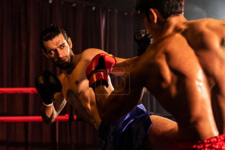 Photo for Asian and Caucasian Muay Thai boxer unleash kick attack in fierce boxing match. Thai boxer with strong muscular body exchanging punch and kick strike with relentless combat prowess. Impetus - Royalty Free Image
