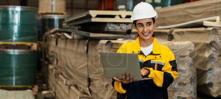Photo for Female engineer or factory inspector conduct inventory check and quality control for metal steel material, contributing in heavy industrial output optimization and manufacturing safety. Exemplifying - Royalty Free Image