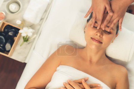 Foto de Panorama vista superior de la mujer disfrutando de relajante masaje de la cabeza anti-estrés y mimar belleza facial recreación de la piel de ocio en dayspa ambiente de luz moderna en el complejo de lujo o salón de spa del hotel. Silencioso. - Imagen libre de derechos