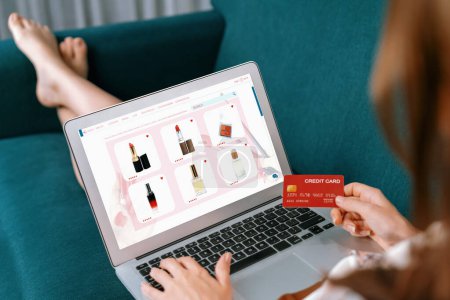 Photo for Woman shopping online on internet marketplace browsing for sale items for modern lifestyle and use credit card for online payment from wallet protected by utmost cyber security software - Royalty Free Image