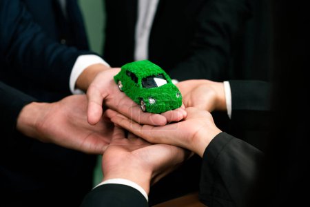 Photo for Business people holding EV car model as business synergy partnership unite and take action to utilized eco-transportation to reduce CO2 emission for sustainable and greener future. Quaint - Royalty Free Image
