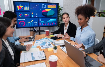 Photo for Multiracial analyst team use BI dashboard data to analyze financial report on meeting table. Group of diverse business people utilize data analysis by FIntech for business marketing decision. Concord - Royalty Free Image