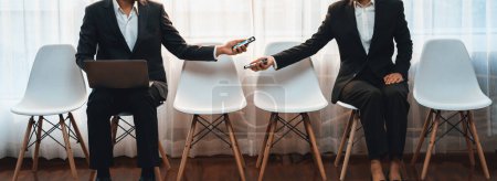Photo for Job applicant sitting in on chair at waiting room with corridor, job seeker candidate talking, showing resume while waiting for job interview. Friendship in career opportunity concept. Trailblazing - Royalty Free Image