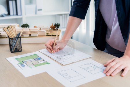 Photo for Closeup hand drafting interior house design by architect designer planning home layout on blueprint paper on office desk. Architect carefully draw home interior layout with pencil and tool. Iteration - Royalty Free Image
