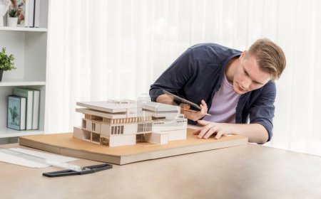 Photo for Architect designer studies elegant house model, reviewing structure design for improvement with construction plan on table. Creativity and innovation in architectural design. Iteration - Royalty Free Image