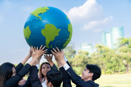 Téléchargez les photos : Concept de journée de la Terre avec grand globe terrestre tenu par un groupe de gens d'affaires asiatiques équipe de promotion de la sensibilisation à l'environnement avec la durabilité environnementale et le principe ESG pour un avenir plus brillant. Pneumatique - en image libre de droit