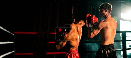 El boxeador tailandés asiático y caucásico Muay desencadena un ataque de codo en una feroz sesión de entrenamiento de boxeo, entregando el golpe de codo al entrenador de sparring, mostrando la técnica y habilidad de boxeo. Espuela
