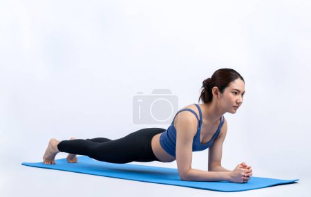 Foto de Ajuste joven asiática mujer planeando en la esterilla de ejercicio. Rutina de entrenamiento de estilo de vida saludable en antecedentes aislados. Equilibrio y resistencia ejerciendo el concepto. Vigoroso - Imagen libre de derechos