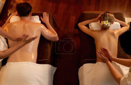 Photo for Top view couple customer enjoying relaxing anti-stress spa massage and pampering with beauty skin recreation leisure in warm candle lighting ambient salon spa at luxury resort or hotel. Quiescent - Royalty Free Image