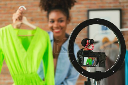Photo for Woman influencer shoot live streaming vlog video review clothes crucial social media or blog. Happy young girl with apparel studio lighting for marketing recording session broadcasting online. - Royalty Free Image