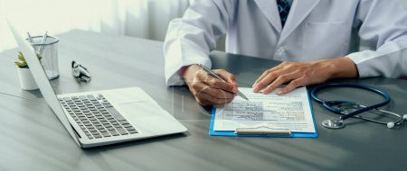 Photo for Doctor carefully review detailed medical report with laptop and diagnosing illness for effective healthcare treatment plan for patient in doctor office. Professional medical evaluation. Neoteric - Royalty Free Image