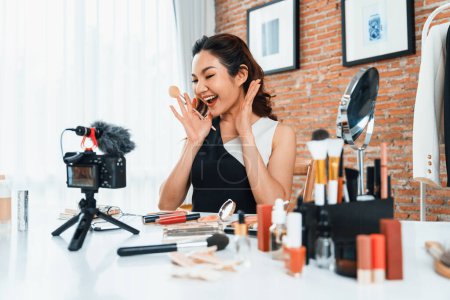 Photo for Asian Woman influencer shoot live streaming vlog video review makeup uttermost social media or blog. Happy young girl with cosmetics studio lighting for marketing recording session broadcasting online - Royalty Free Image