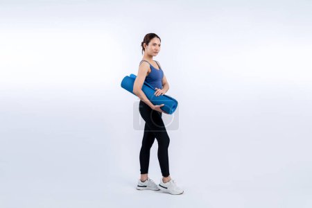 Foto de Joven mujer asiática atractiva retrato en ropa deportiva con colchoneta de ejercicio. Ejercicio saludable y ejercicio concepto de rutina de estilo de vida. Estudio filmó fondo aislado. Vigoroso - Imagen libre de derechos