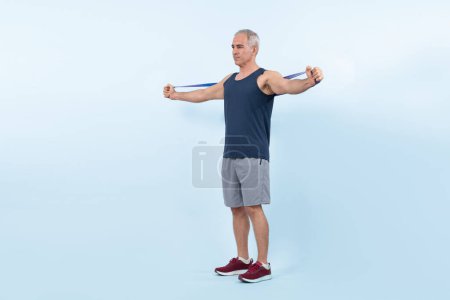 Photo for Full body length shot athletic and sporty senior man with fitness resistance band on isolated background. Healthy active physique and body care lifestyle after retirement. Clout - Royalty Free Image