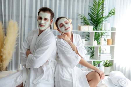 Photo for Blissful couple in bathrobe with facial cream mask enjoying serene ambiance of spa salon resort or hotel during holiday. Pampering face spa and skincare treatment with essence relaxation. Quiescent - Royalty Free Image