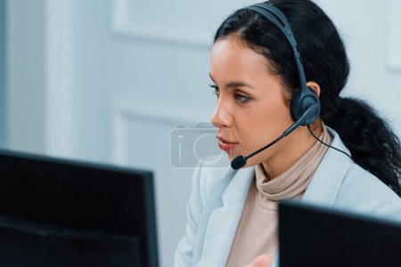 Photo for African American young businesswoman wearing headset working in office to support remote crucial customer or colleague. Call center, telemarketing, customer support agent provide service on video call - Royalty Free Image