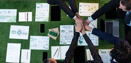 Photo for Business synergy in panoramic top view banner of business people holding hand together as team building for eco regulation for environmental protection to contribute sustainable future. Quaint - Royalty Free Image
