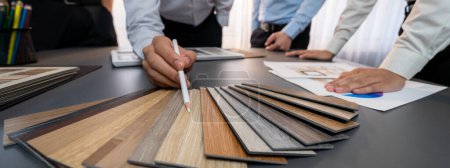 Photo for Group of interior designer team in meeting, discussing with engineer on interior design and planning for house project blueprint and model, choosing various mood board materials. Insight - Royalty Free Image