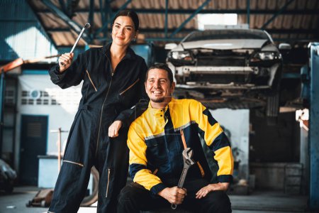 Photo for Two happy vehicle mechanic celebrate and high five after made successful car inspection or repair in automotive service car workshop. Technician team enjoy accomplishment together in garage. Oxus - Royalty Free Image