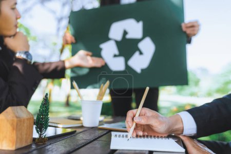 Photo for Group of businesspeople meeting at outdoor office in the nature planning and brainstorming on recycle strategy for greener environment by reducing and reusing recyclable waste. Gyre - Royalty Free Image