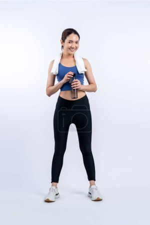 Photo for Athletic and sporty asian woman resting and drink water after intensive cardio workout training. Healthy exercising and fit body care lifestyle pursuit in studio shot isolated background. Vigorous - Royalty Free Image