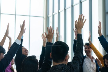 Foto de Los empresarios exitosos levantaron sus manos para votar mostrando su aprobación como voluntarios en el seminario de la oficina con felicidad. Los gerentes de sonrisas levantan las manos. Intelectual. - Imagen libre de derechos