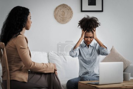 Photo for Sad PTSD woman patient in crucial therapy for mental health with psychologist, depression or grief after life failure. Frustrated trauma young woman talking to a psychologist about emotion in clinic - Royalty Free Image