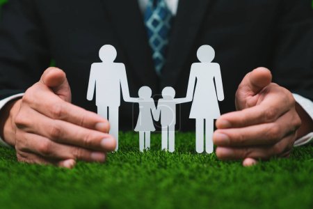 Photo for Background of paper family icon held in hand symbolize dedication to environmental friendly lifestyle of modern family, parenthood guiding sustainable lifestyle to their children. Gyre - Royalty Free Image