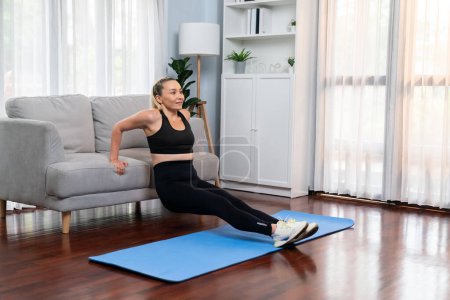 Photo for Athletic and active senior woman using furniture for effective targeting muscle with push up at home exercise as concept of healthy fit body lifestyle after retirement. Clout - Royalty Free Image