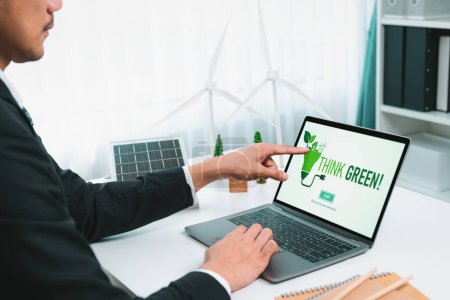 Photo for Businessman working in office developing plan or project on eco-friendly alternative energy with solar cell technology display on computer screen for greener environment as apart of CSR effort. Gyre - Royalty Free Image