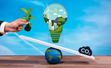 Photo for Businessman balance light bulb on scale with CO2 emission icon, demonstrate concept of ESG commitment and environmental conservative idea to carbon reduction through clean energy technology. Reliance - Royalty Free Image