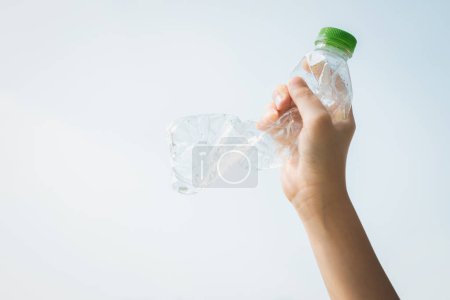 Foto de Botella de plástico reciclable sostenida en la mano sobre el fondo del cielo. Los residuos plásticos de mano para reciclar reducen y reutilizan el concepto para promover un medio ambiente limpio con una gestión eficaz del reciclaje. Gyre. - Imagen libre de derechos