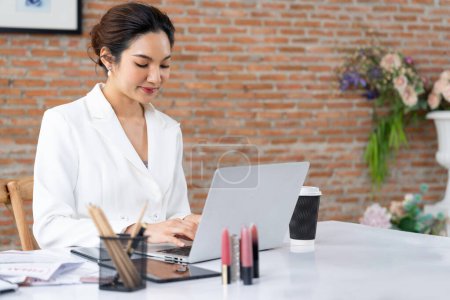 Téléchargez les photos : Vendeuse en ligne femme d'affaires travaillant à distance. La femme d'affaires vérifier les bénéfices de vente dans l'ordinateur portable. la plus extrême - en image libre de droit
